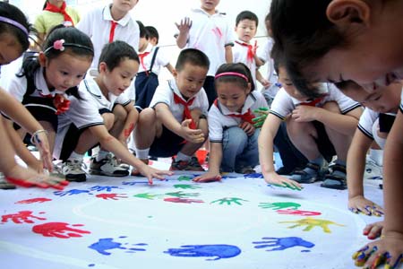 Students make a drawing at Huanfeng Primary School in Hanshan County, east China's Anhui Province, Sept. 9, 2008. The students put their hand prints on a huge cloth to form number '9.10', indicating the date of Chinese teacher's Day, as a gift for their teachers.(Xinhua/Cheng Qianjun)